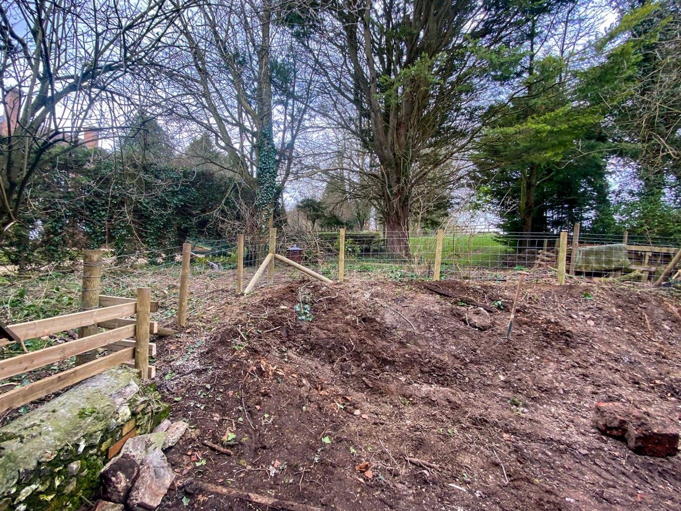 Stock fencing going around an area that has recently been dug up.