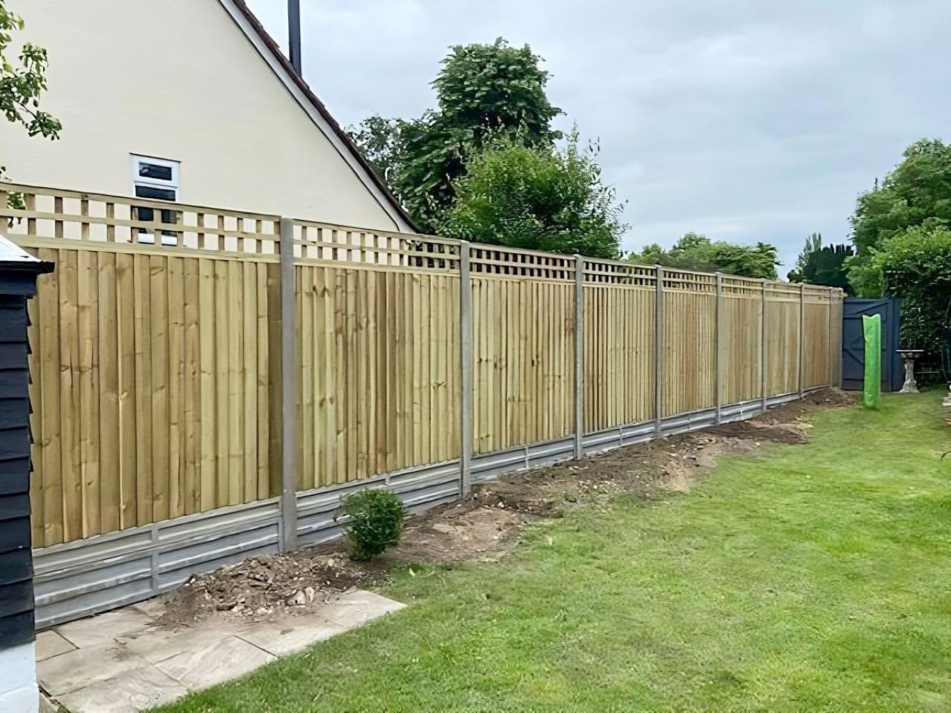 Closeboard fence with trellis on top.