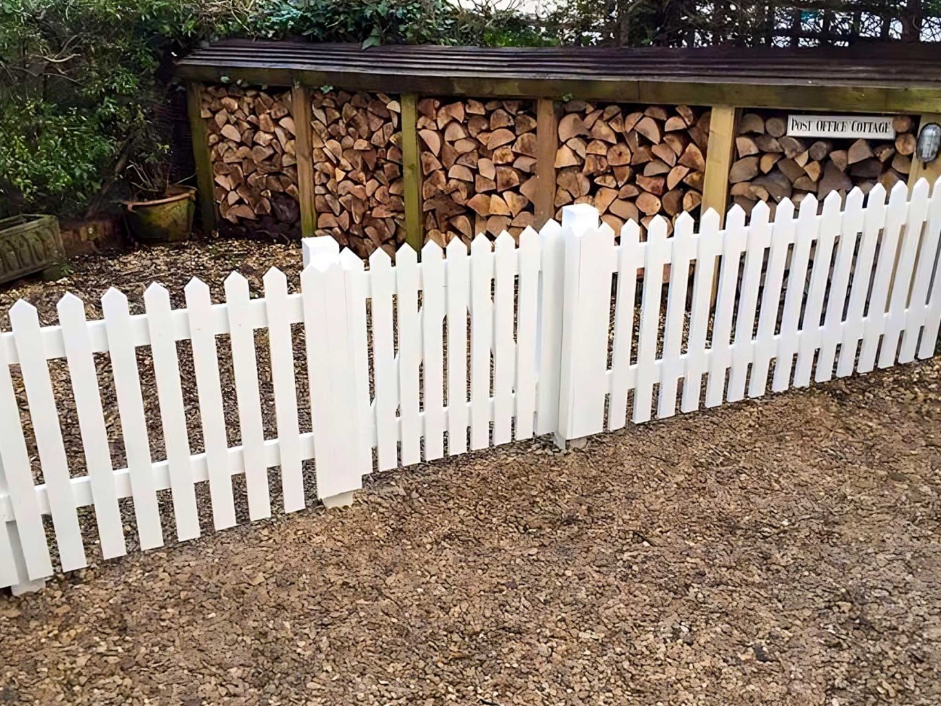 Small white picket gate with white picket fencing either side.