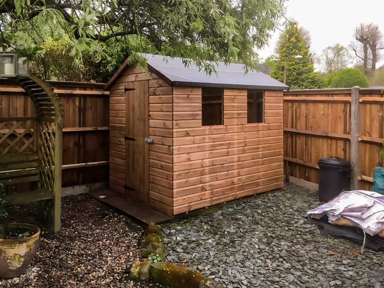 Medium sized garden shed with two side windows and front door.