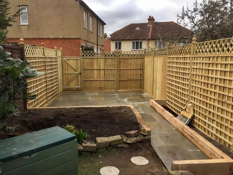 Completed landscaping project in garden with new patio and fencing.