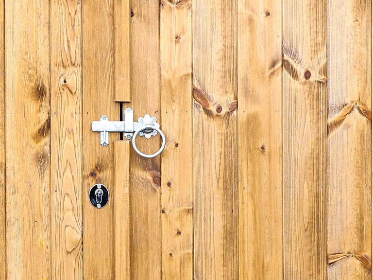 Close up of double gate with rounded metal handle.