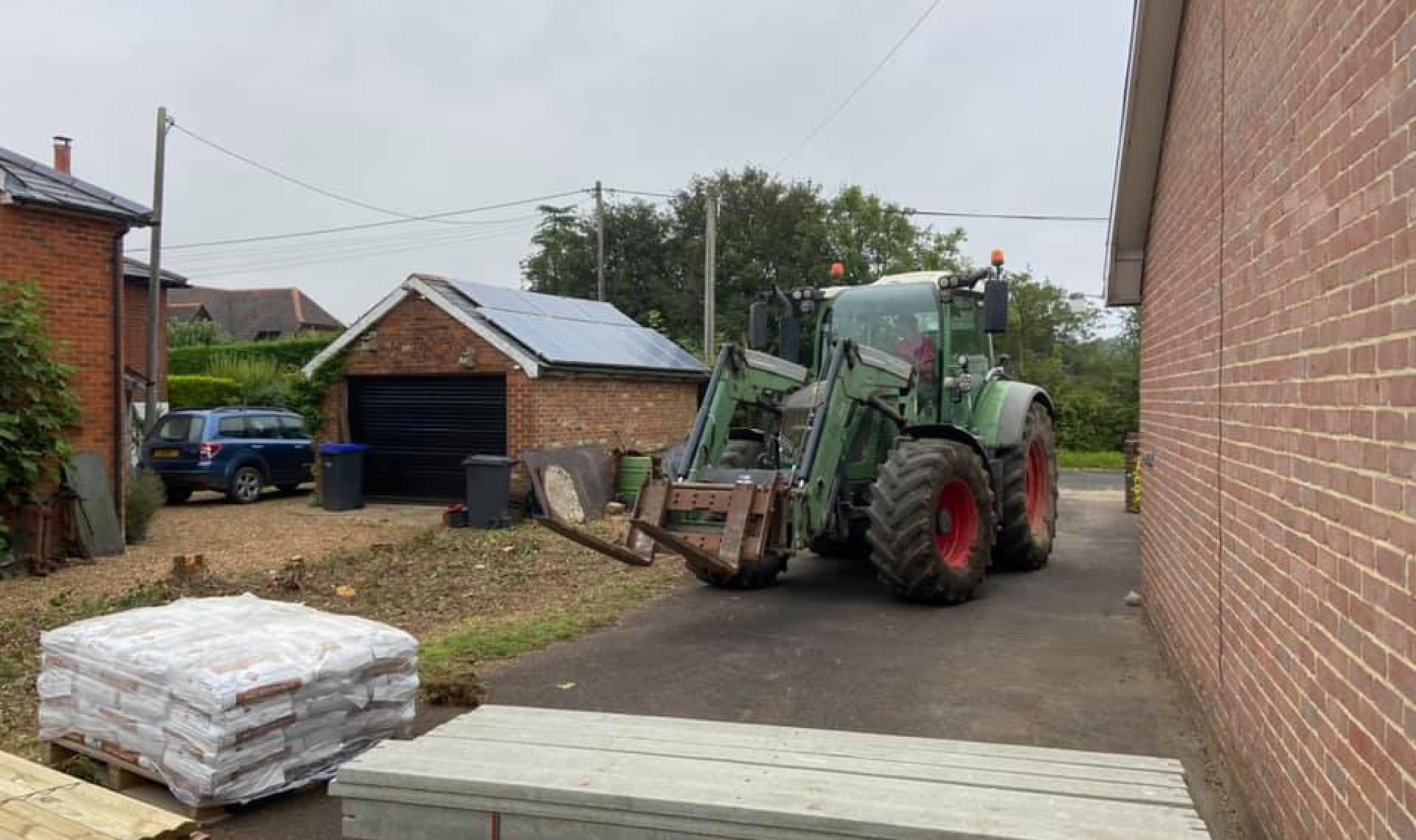 Green tractor moving onto the whiteparish property pre-fence installation.