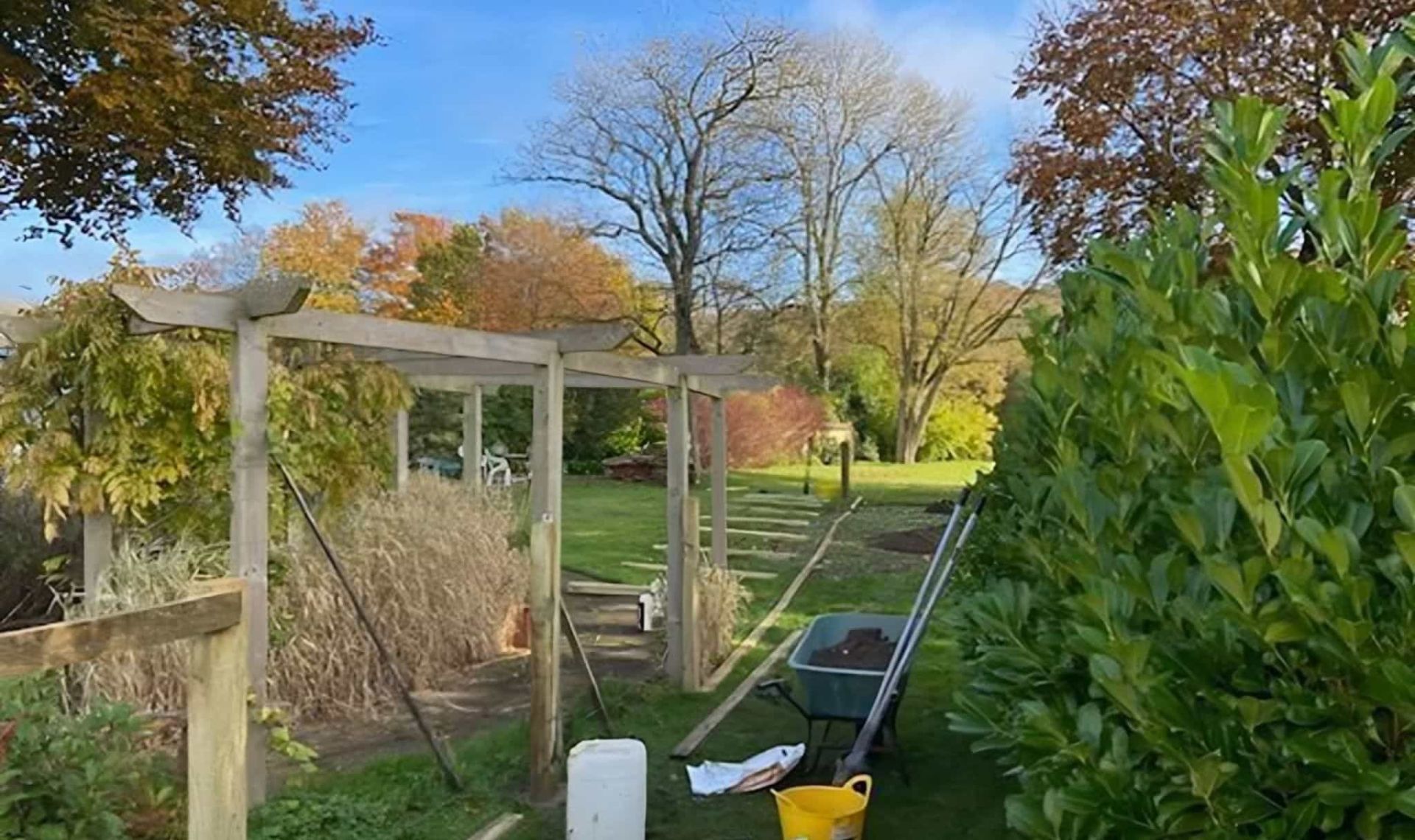 High vertical fence posts being installed in a large garden.